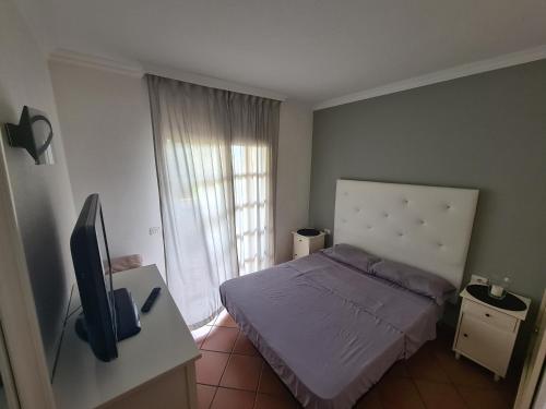 Dormitorio pequeño con cama y TV en La Quinta Relax, en Santa Úrsula