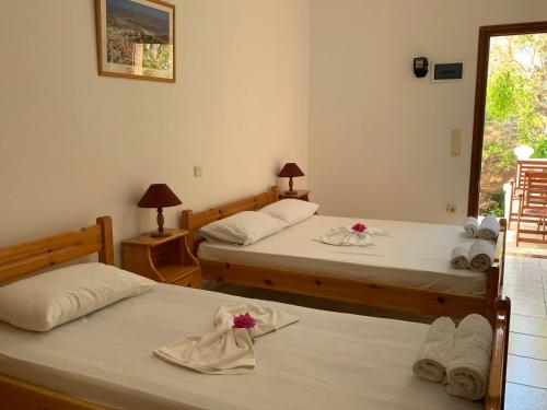 a room with two beds with towels on them at Studios Irene in Skala