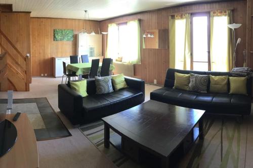 - un salon avec deux canapés et une table dans l'établissement Chalet Tyl, vue imprenable sur les Alpes Valaisannes, à Crans-Montana