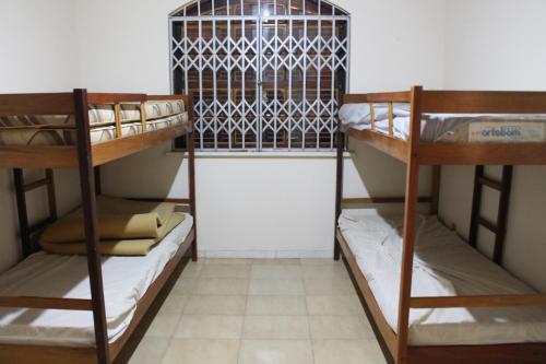a room with three bunk beds in a room at Casa muito espaçosa privativa com Piscina, Churrasqueira e área gourmet in Araruama