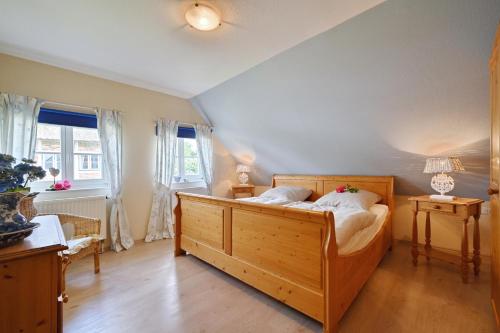 a bedroom with a large wooden bed with white pillows at Landhaus Vilmnitz - Wohnung 2 in Vilmnitz