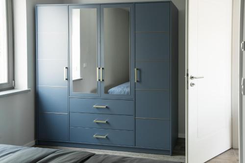 a bedroom with a blue cabinet with a mirror at Saphir Quartier in Quedlinburg