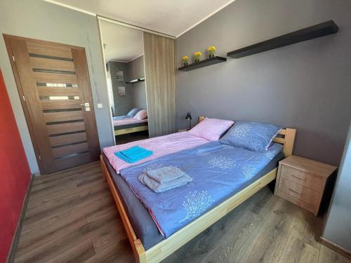 a small bedroom with a bed and a mirror at Gdynia Apartament 42 m z miejscem w Garażu z Windą blisko centrum i morza in Gdynia