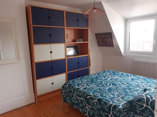 a bedroom with a bed and a dresser at Appartement Malo les Bains à deux pas de la plage in Dunkerque