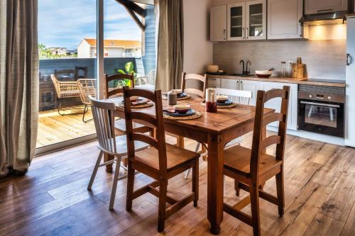 kuchnia i jadalnia z drewnianym stołem i krzesłami w obiekcie Mamita1"Apartment delight of the pines"spacious bright T3 62m18mterrace w mieście Lacanau