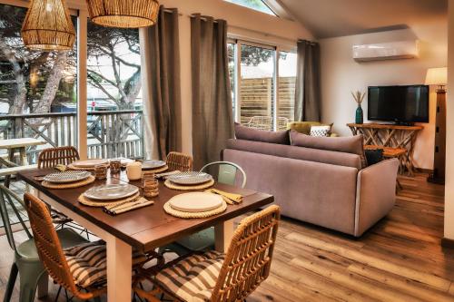 a living room with a table and a couch at MAMITA 2 beautiful spacious and bright apartment T4 74m 18m of terrace in Lacanau-Océan