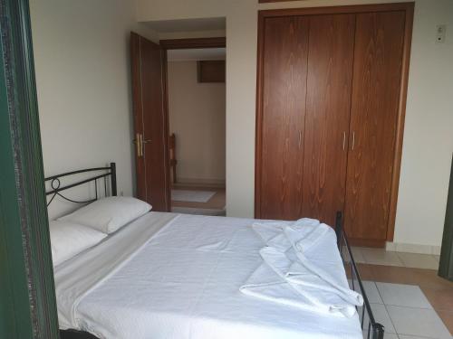 a bedroom with a bed and a wooden cabinet at Papadeas Villas in Megáli Mandínia