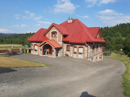 una casa con techo rojo en una carretera en Zamoček en Matiašovce
