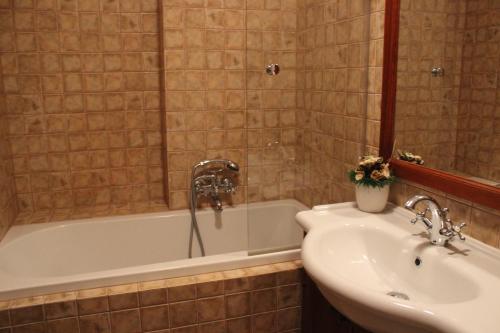 a bathroom with a sink and a bath tub and a sink at Penzion U Veterána in Slatinice
