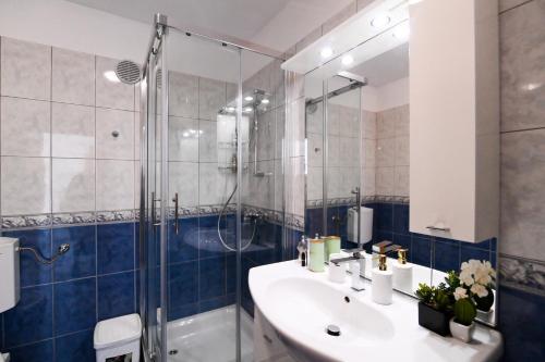 ein Bad mit einem Waschbecken und einer Dusche in der Unterkunft Rossy in Rijeka