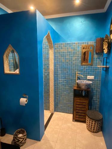 a blue bathroom with a sink and a blue wall at Riad Agraba, 1001 nights in Lomm