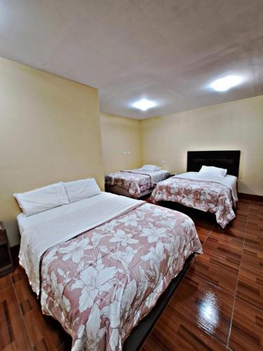 two beds in a hotel room with two beds at La Ruta in Paracas