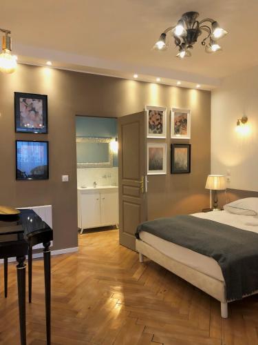 a bedroom with a bed and a desk and a piano at Hôtel D’Artiste in Pierrefontaine-les-Varans