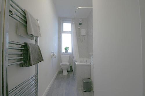 Baño blanco con aseo y lavamanos en Charming 3-Bed House in Whitwell village, en Worksop