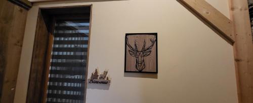 a painting of a deer hanging on a wall at Cier de Riviere "Les Cerfs" in Cier-de-Rivière
