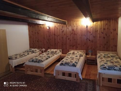 3 Betten in einem Zimmer mit Holzwänden in der Unterkunft Chalupa Praženica in Liptovské Revúce