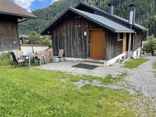 a small cabin with a table and chairs in a yard at Haus Mangard in Sankt Gallenkirch