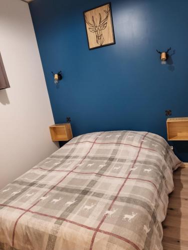 Cier-de-Rivière的住宿－Cier de Riviere "Les Cerfs"，一间卧室配有一张蓝色墙壁的床