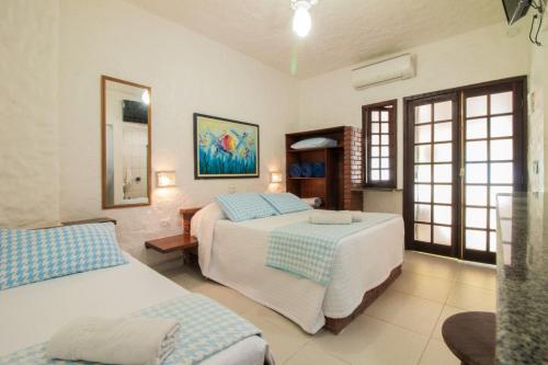 a bedroom with two beds and a window at Apart Hotel Porto Kanoas in Bertioga