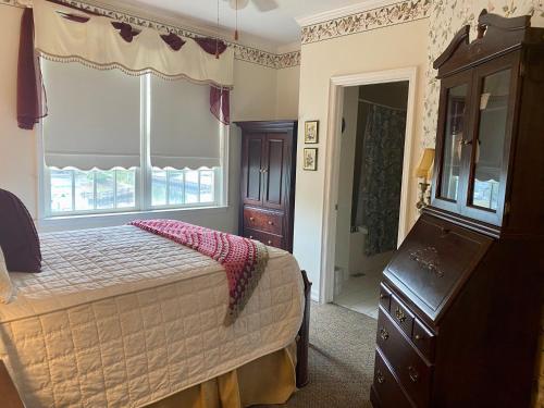 a bedroom with a bed and a dresser and a window at The Cypress Inn in Conway