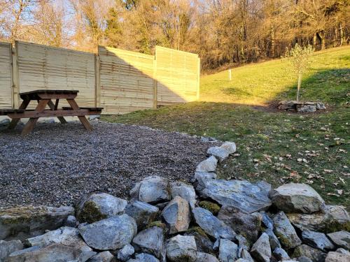 a picnic table and a pile of rocks at Cier de Riviere "Les Cerfs" in Cier-de-Rivière