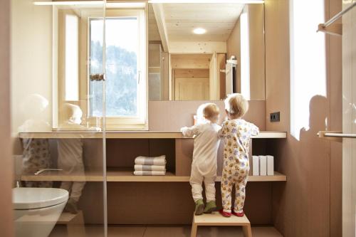 zwei Kinder stehen auf einem Regal in einem Badezimmer in der Unterkunft Ferienhaus Islen in Mellau