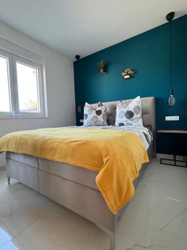 a bedroom with a large bed with a yellow blanket at Poolhouse Flip Flop - mit privatem Pool in Vir