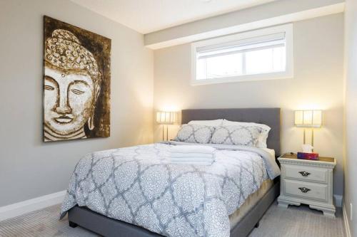 a bedroom with a bed with a painting on the wall at Stunning 2 BDRM YEG Suite, EIA Airport, WiFi! in Edmonton