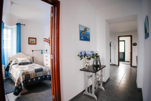 sypialnia z łóżkiem i stołem z wazonem kwiatów w obiekcie Casa das Palmeiras w mieście São Vicente Ferreira