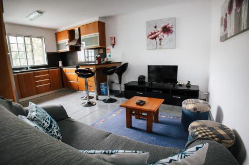 a living room with a couch and a table at Casa das Palmeiras in São Vicente Ferreira