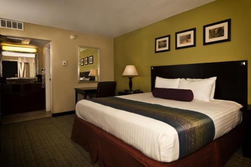 a hotel room with a large bed and a bathroom at Grand Texan Hotel and Convention Center in Midland