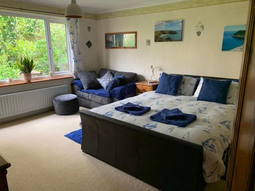 a bedroom with a bed and a couch in it at West Winds, Fore Street, Polruan by Fowey in Polruan