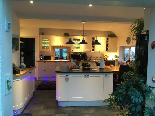 a kitchen with white cabinets and a black counter top at West Winds, Fore Street, Polruan by Fowey in Polruan