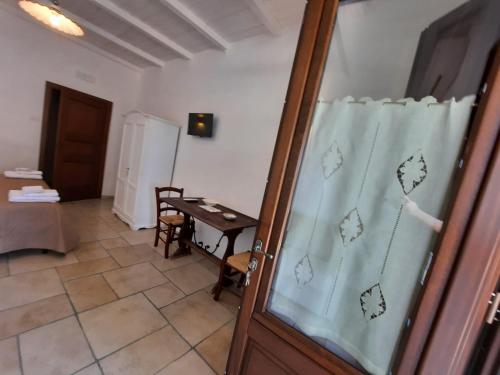 Habitación con mesa y puerta de cristal en masseria LAMA DI GALIZIA, en Ostuni