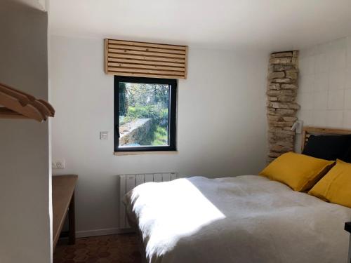 1 dormitorio con cama y ventana en Logement calme avec vue sur le Luberon en Saignon