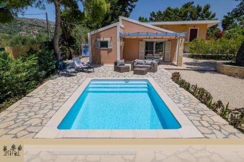 a swimming pool in front of a house at Ponderosa in Lixouri