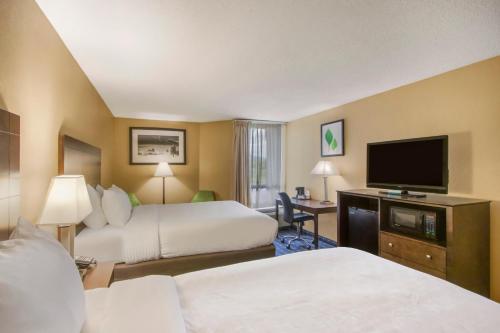 a hotel room with two beds and a flat screen tv at Clarion Inn Asheville Airport in Fletcher