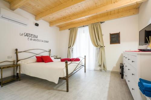 a bedroom with a bed with red pillows at Casa Mirto in Bosa