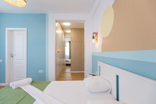 een blauwe en witte slaapkamer met een bed en een hal bij Casa Eden in Costinesti