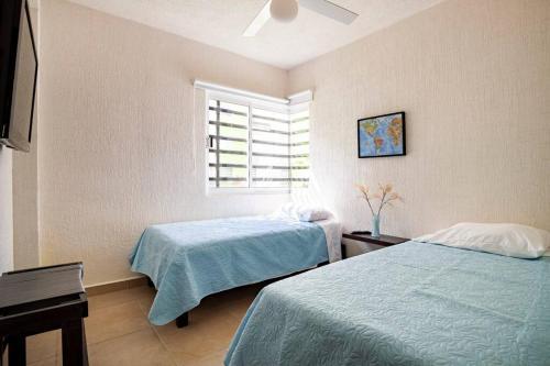 a bedroom with two beds and a window at El descanso del guerrero in Barra Vieja