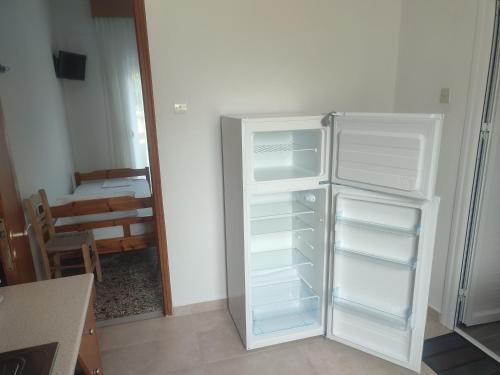 パラリア・スコティニスにあるMichalos Apartmentsの白い冷蔵庫(キッチン内のドアが開く)