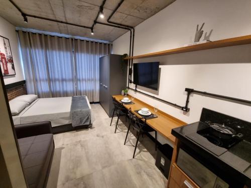 ein kleines Zimmer mit einem Bett und einem Schreibtisch. in der Unterkunft APTO Studios in Itajaí