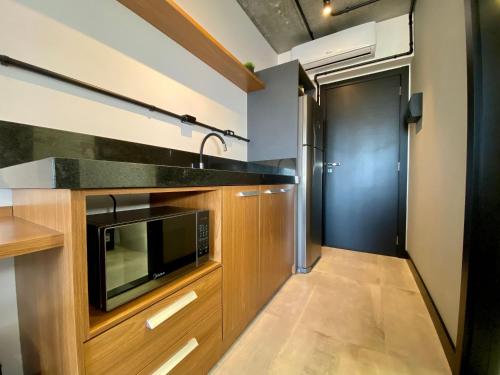 a kitchen with a sink and a microwave at APTO Studios in Itajaí