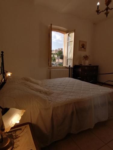 a bedroom with a white bed and a window at La Musa di Spello in Spello