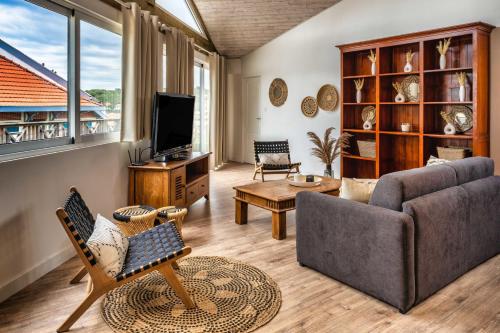 a living room with a couch and a tv at Mamita 3"Salty dreams apartment"spacious and bright T3 84m 35m terrace in Lacanau-Océan