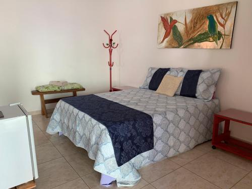 a bedroom with a bed with a blue comforter at Estancia Maria in Pirenópolis