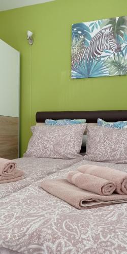 a bedroom with a bed with pink towels on it at Apartman Harmonija Vrnjačka Banja in Vrnjačka Banja