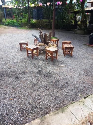 a group of benches sitting around a fire pit at Sítio Martins com lazer completo em Ibiúna, SP in Ibiúna