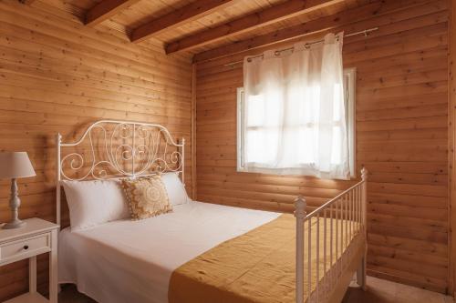 a bedroom with a white bed in a wooden room at Wood House "Private Spa" in Vergia