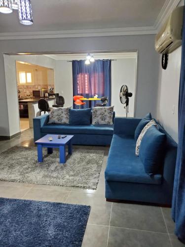 10月6日市にあるSpacious 3 bedroom apartment - FAMILIES ONLYの青いソファとテーブルのあるリビングルーム